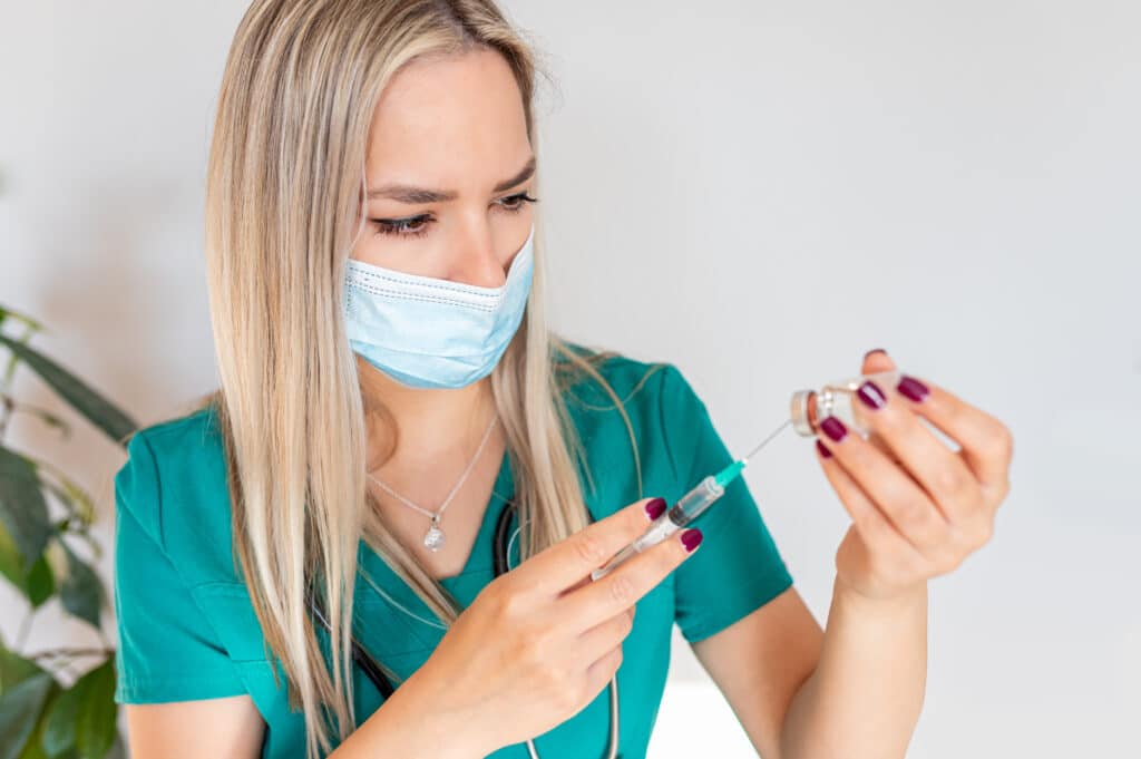 Aesthetic Nurse injector drawing botox out of a vial.